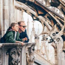 a man and a boy sitting on a balcony