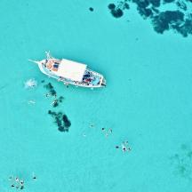 an aerial view of a boat in the water with people