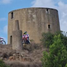 dues persones anant amb motos de cross davant d'una torre
