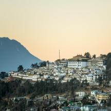a town on a hill with a mountain in the background