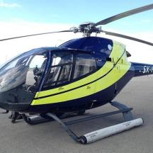 a blue and yellow helicopter parked on a runway