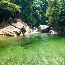 a river with green water and a waterfall