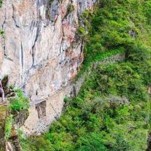 a person standing on a path through a mountain