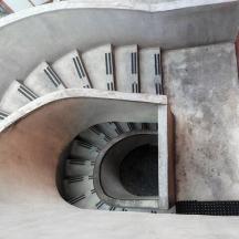 Una escalera de caracol en un edificio con una pared roja.