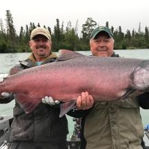 two men holding a large fish in a boat