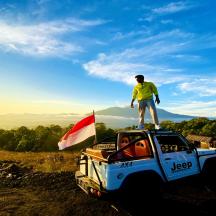 a man standing on the roof of a jeep