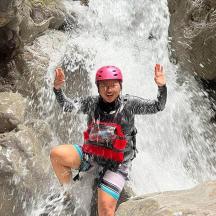 a man in a helmet standing in front of a waterfall