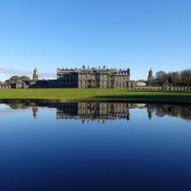 a large castle with a lake in front of it