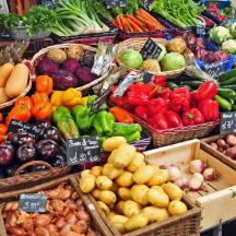 un'esposizione di frutta e verdura in cesti in un mercato
