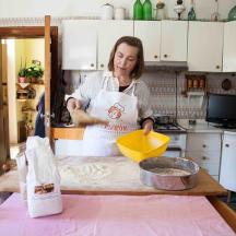 a woman standing in a kitchen preparing food