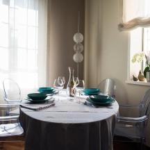 a dining room table with a white table cloth and chairs