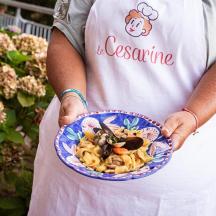 una donna che tiene in mano una ciotola di pasta