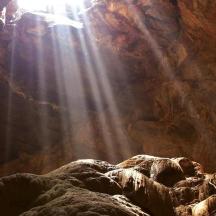 a cave with the sun shining inside of it
