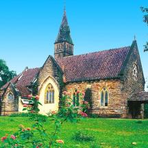 a church with a tower on top of a green field