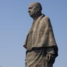 a statue of a man standing in front of a blue sky