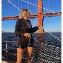 a woman standing on a boat in front of a bridge