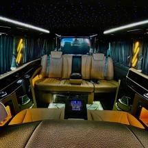 eine Innenansicht einer Limousine mit Rücksitz und Tischen und Sitzen
