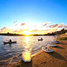 a group of boats in the water at sunset