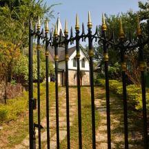an iron fence with a house in the background