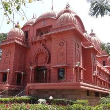 a large pink building with a balcony
