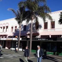 a group of people crossing a street in front of a building