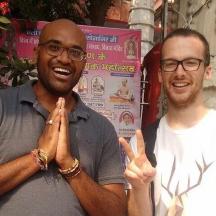 two men holding their hands up while smiling