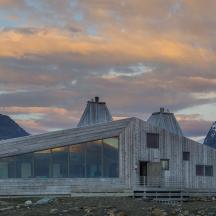 a house on a hill with mountains in the background