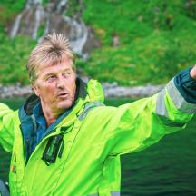 a man in a yellow jacket standing in the water