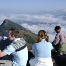 eine Gruppe von Menschen, die auf einem Berggipfel sitzen