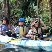 three people in a kayak on a river