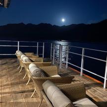 a row of chairs on the deck of a cruise ship at night