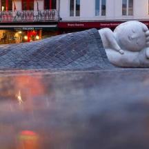 o statuie a unei femei așezate pe stradă