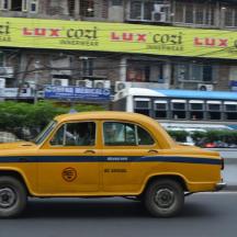 a yellow car driving down a city street