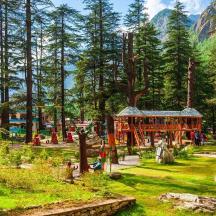 a playground in a park with trees and a building