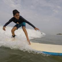 a young boy riding a wave on a surfboard in the ocean