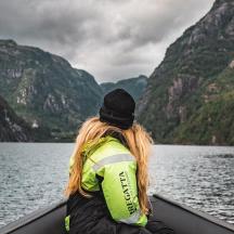 a woman is sitting in a boat on a lake