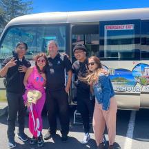 a group of people standing in front of a bus
