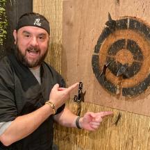 ein Mann steht vor einer Holzwand