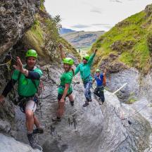 a group of people in green shirts climbing a mountain