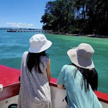 two women in hats on a boat in the water