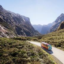 a bus driving down a road in the mountains