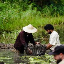 two men in the water with a basket in the water