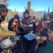a group of people sitting around a grill