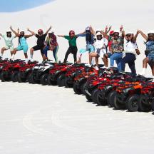 a group of people standing on a row of motorcycles in the snow