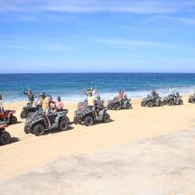 en gruppe mennesker, der kører på ATV'er på stranden