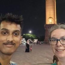 a man and a woman standing in front of a clock tower