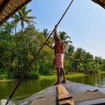 a man is standing on a boat on a river