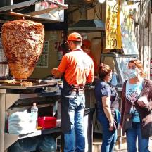 a group of people standing in front of a food stand
