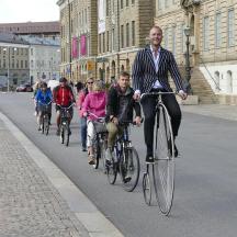 en gruppe mennesker, der cykler ned ad en gade