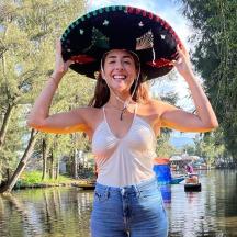 una donna che indossa un cappello in piedi davanti a un fiume